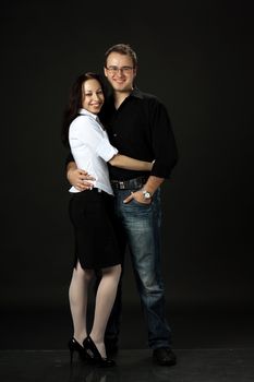 beautiful young smilling couple posing standing in studio