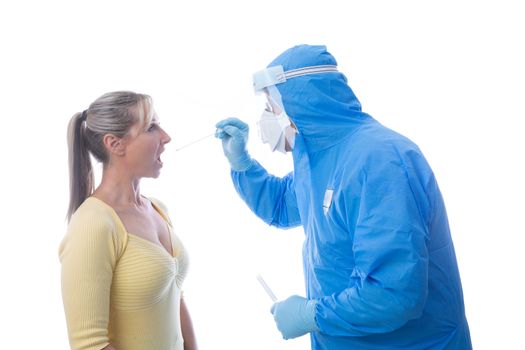 Medical pathologist  in full coverall disposable PPE is swabbing a female patient for an infectious virus or disease.  Coronavirus COVID-19 is a highly contagious virus sweeping the globe
