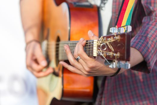 man playing acoustic guitar with nature light