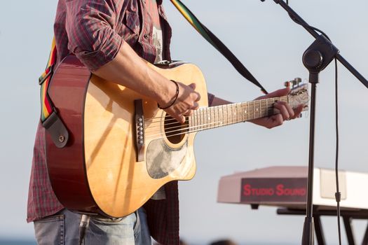 man playing acoustic guitar with nature light