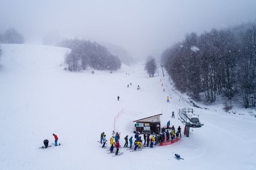 Naousa, Greece - January 13, 2018: Aerial View of skiers at Ski Resort 3-5 pigadia during the snowfall in the mountain Vermio.It is a modern ski resort with ski slopes with every degree of difficulty