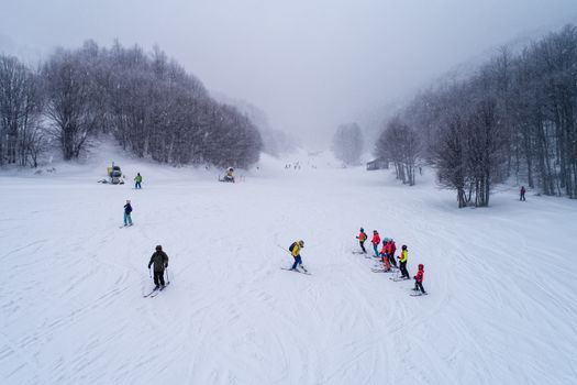 Naousa, Greece - January 13, 2018: Aerial View of skiers at Ski Resort 3-5 pigadia during the snowfall in the mountain Vermio.It is a modern ski resort with ski slopes with every degree of difficulty