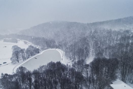 Aerial view of forest in the winter during the snowfall in the area of Naoussa in northern Greece. Captured from above with a drone.