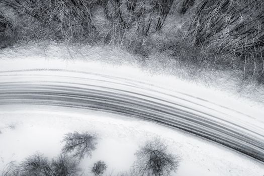 Aerial view of snowy forest with a road in the area of Naoussa in northern Greece.  Captured from above with a drone.