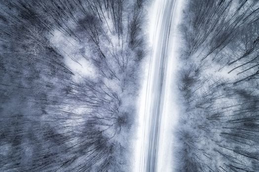 Aerial view of snowy forest with a road in the area of Naoussa in northern Greece.  Captured from above with a drone.