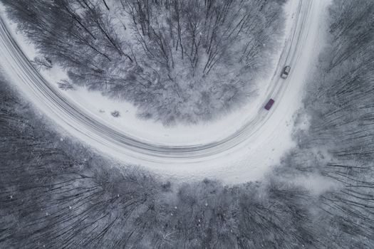 Aerial view of snowy forest with a road in the area of Naoussa in northern Greece.  Captured from above with a drone.