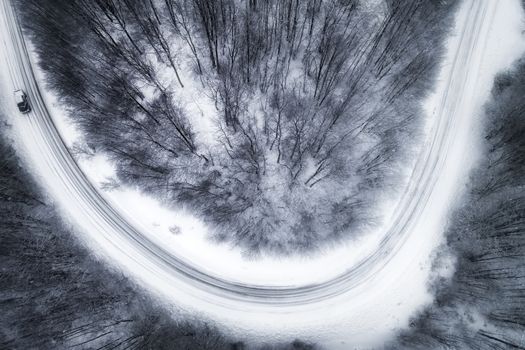 Aerial view of snowy forest with a road in the area of Naoussa in northern Greece.  Captured from above with a drone.