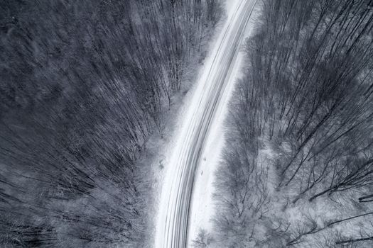 Aerial view of snowy forest with a road in the area of Naoussa in northern Greece.  Captured from above with a drone.