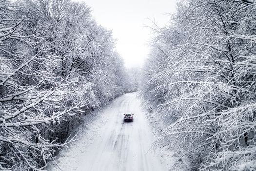 Aerial view of snowy forest with a road in the area of Naoussa in northern Greece.  Captured from above with a drone.