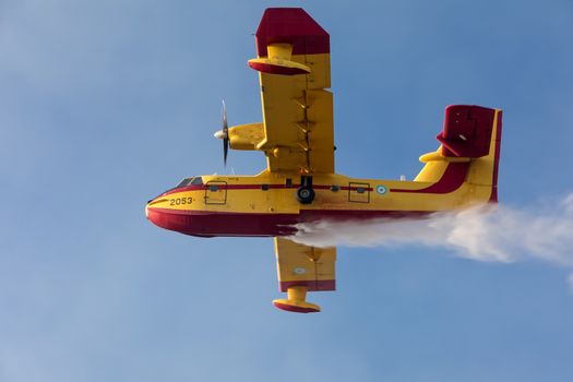 Chalkidiki, Greece - Sept 22, 2017: A firefighting aircraft releases the load of water as it tries to extinguish a fire in a pine forest in Kassandra, Chalkidiki