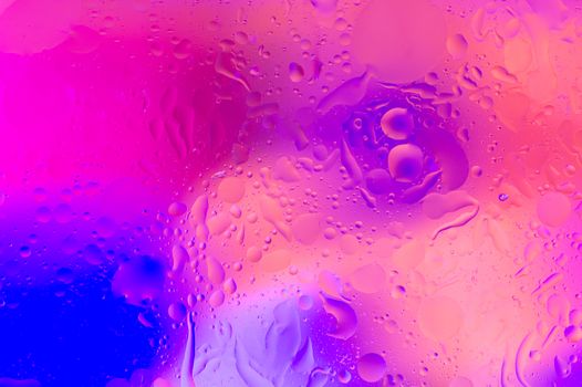 The hue purple abstract composition of oil drops in water with soft focus effect.