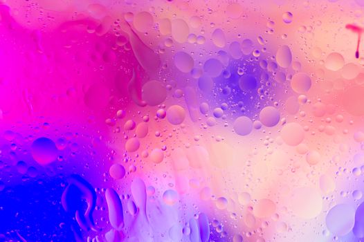 The purple abstract composition with oil drops in water with soft focus effect.