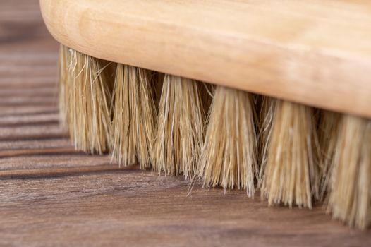 Vintage shoe brush with wooden handle on wooden background. Close up view with small depth of field.