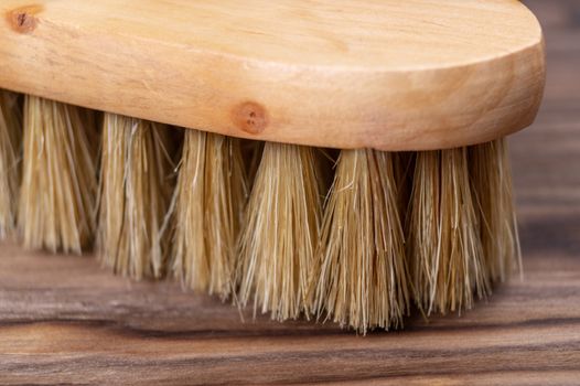 Vintage shoe brush with wooden handle on wooden background. Close up view with small depth of field.