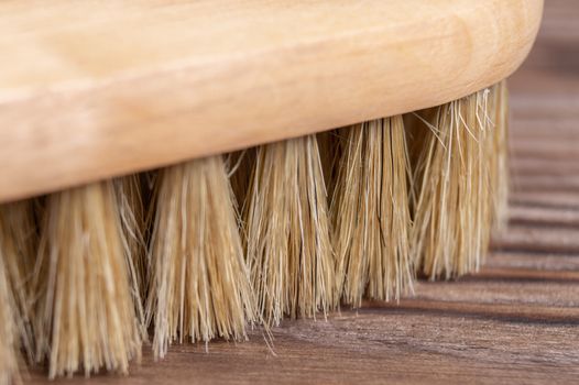 Vintage shoe brush with wooden handle on wooden background. Close up view with small depth of field.