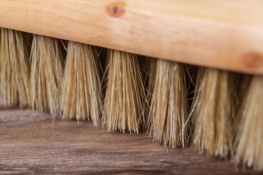 Vintage shoe brush with wooden handle on wooden background. Close up view with small depth of field.