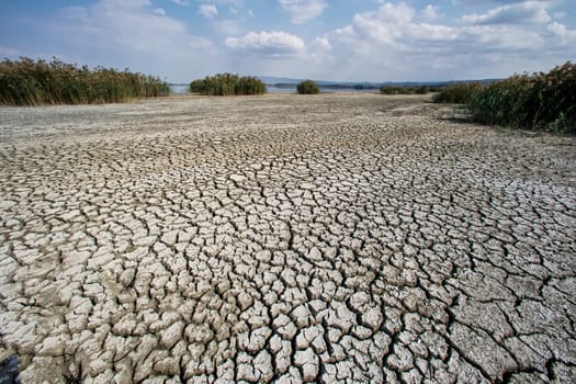 Dry lake bed with natural texture of cracked clay in perspective floor. Death Valley field . background. Selective focus on black soil dark land. Idea concept symbol disaster ecology in nature