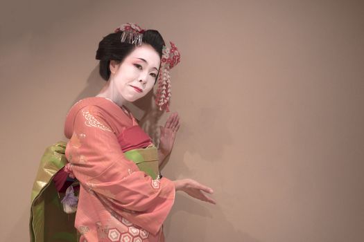 Clipping japanese geisha maiko girl in red kimono coifed hair brooch with patterns of red and white plum blossoms on white background.