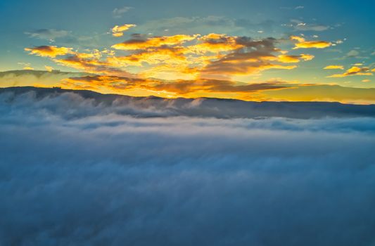 Aerial View. Flying over the clouds . Aerial camera shot. During the sunset. Landscape panorama.