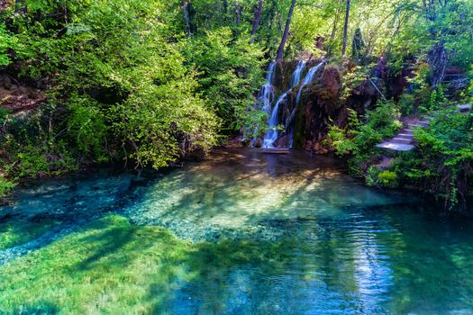 beautiful waterfall and small lake with green waters in the green forest in Skra at north Greece