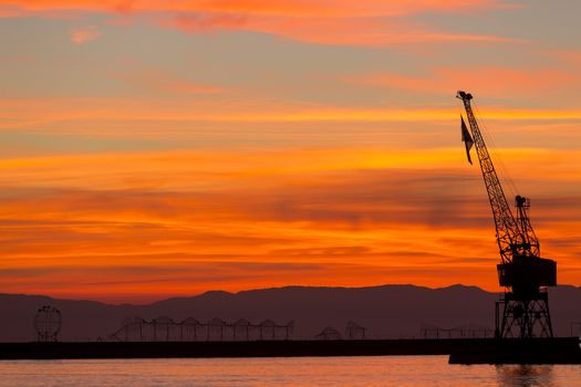 Silhouette of a drilling rig against dramatic sunset