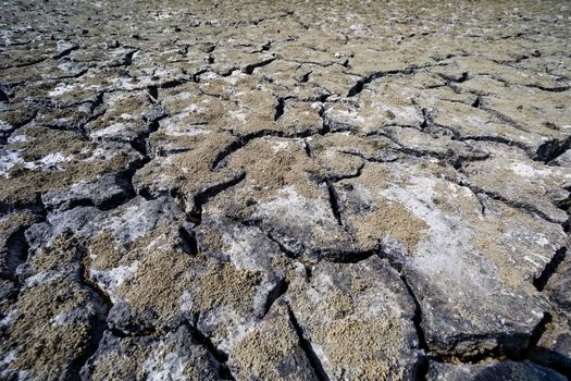 Dry lake bed with natural texture of cracked clay in perspective floor. Death Valley field . background. Selective focus on black soil dark land. Idea concept symbol disaster ecology in nature