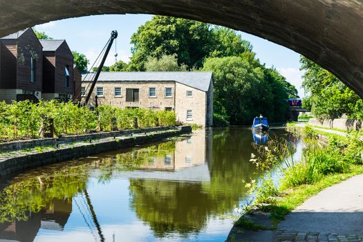 View down Lancaster canal towards a old mill and narrowboat