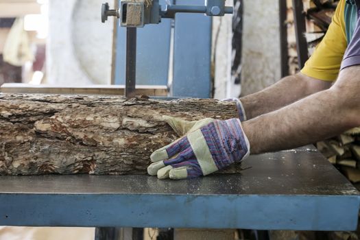 Thessaloniki, Greece, July 8, 2015: Craftsmen cut a piece of wood at a woodworking factory in Greece. Wood and furniture production plant, industrial factory with tools and objects.