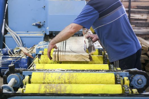 Thessaloniki, Greece, July 8, 2015: Craftsmen cut a piece of wood at a woodworking factory in Greece. Wood and furniture production plant, industrial factory with tools and objects.