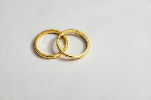 two gold wedding rings on white background