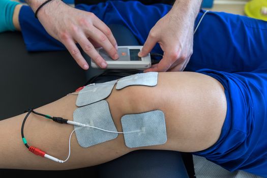 electronic therapy on knee used to treat pain. selective focus