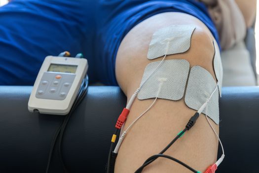 electronic therapy on knee used to treat pain. selective focus