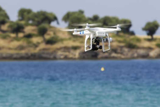 MARMARAS, GREECE- JULY 29, 2014: DJI Phantom drone in flight with a mounted GoPro Hero3+ Black Edition digital camera in Marmaras, Greece. DJI Industries produces unmanned aircraft for surveillance