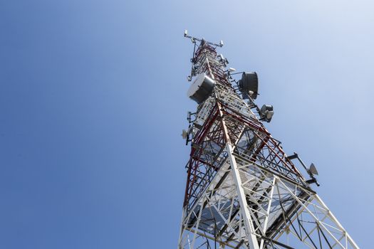 communications tower with antennas against blue sky