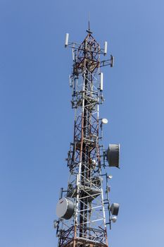 communications tower with antennas against blue sky