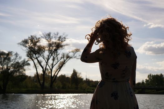 Portrait of woman in profile resting on the nature near the river. Sunny simmer day