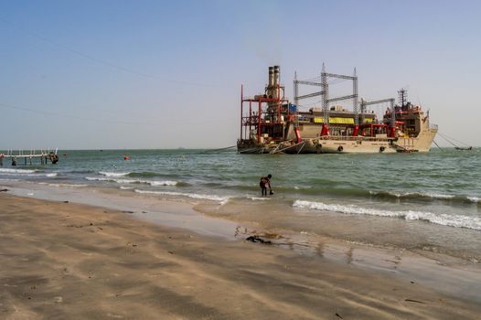 GAMBIA, BIJILO - 07 January 2020: Power plant on moored boats near Banjul beach in The Gambia