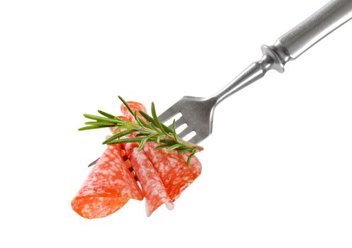 Slices of Hungarian salami and fresh rosemary on fork isolated on white