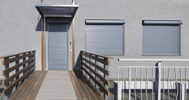Light gray metal blinds on the doors and windows of the house