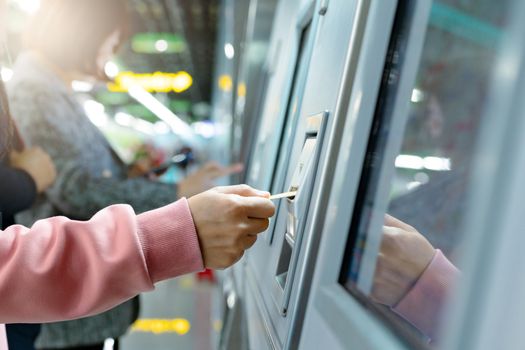 Woman take a train ticket after buy from subway ticket machine. Transportation concept