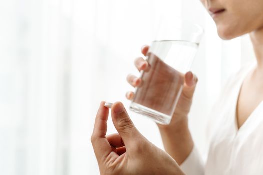 headache women hand hold medicine with a glass of water, healthcare and medicine recovery concept