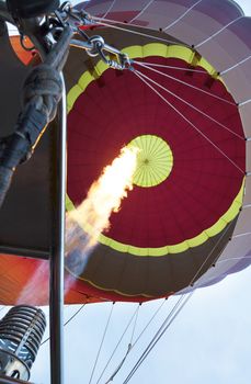 The balloon is blown inflate with fire from the torch, a long flame tongue.
