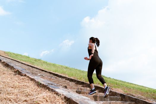 young sport woman running outdoor upstairs on blue sky