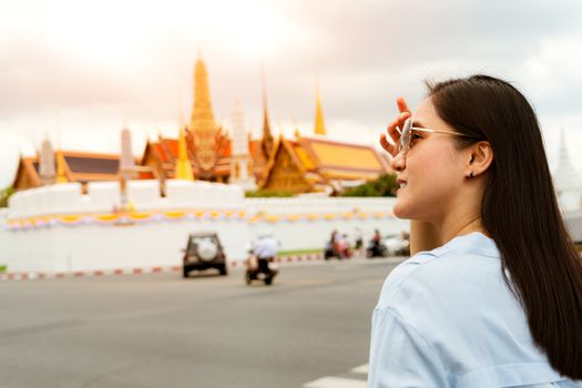 Young Woman traveling to Grand palace and Wat phra keaw at sunset at Bangkok, Thailand