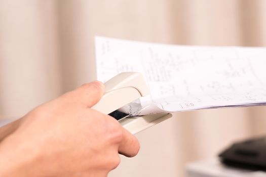 focus on the women hand stapling the hand writing paper, working and office concept