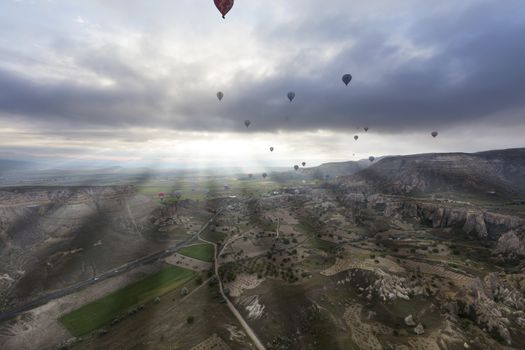 The mountains of Cappadocia impress with their nakedness and openness. Balloons rise above them.