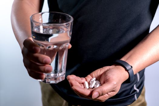 focus on the men hand holding the medicine with a glass of water, medicine recovery concept