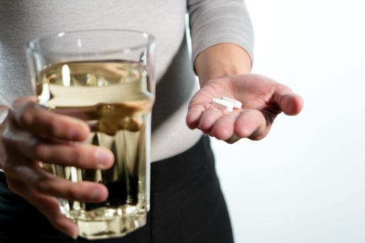 isolate of the women hand holding the medicine with a glass of water, medicine recovery concept
