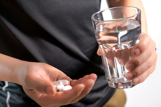 focus on the men hand holding the medicine with a glass of water, medicine recovery concept