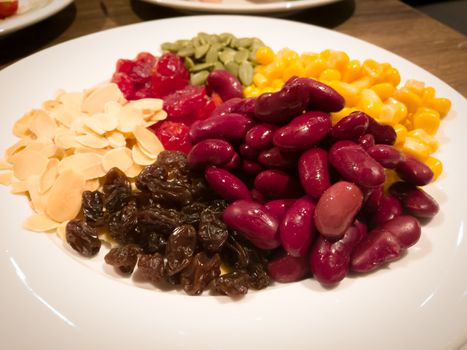 Pile of the steam yellow corn, red bean, sunflower seed, almond, raisin and sweet dried jujube, salad and healthy food
